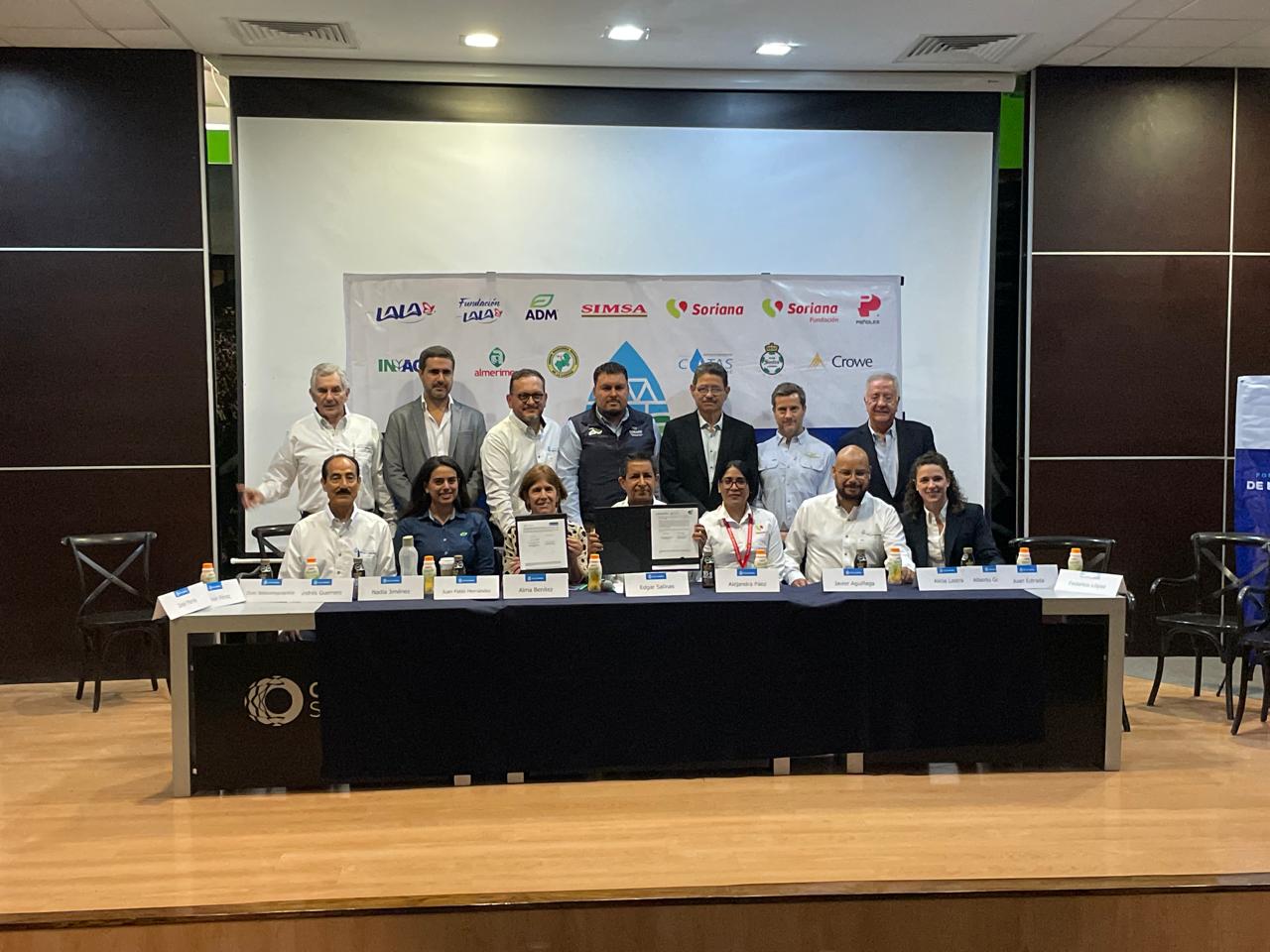 Consejeros del Fondo de Agua de La Laguna, así como representantes de la CONAFOR y la CONANP, en el presídium de la rueda de prensa, sosteniendo los convenios firmados. Atrás los logos del patronato: Lala, Fundación Lala, Simsa, Soriana, Peñoles, Inagro, Almerimex, Unión Ganadera, Cotas, Santos y Crowe.